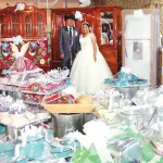 Pareja de recién casados frente a sus regalos de boda 